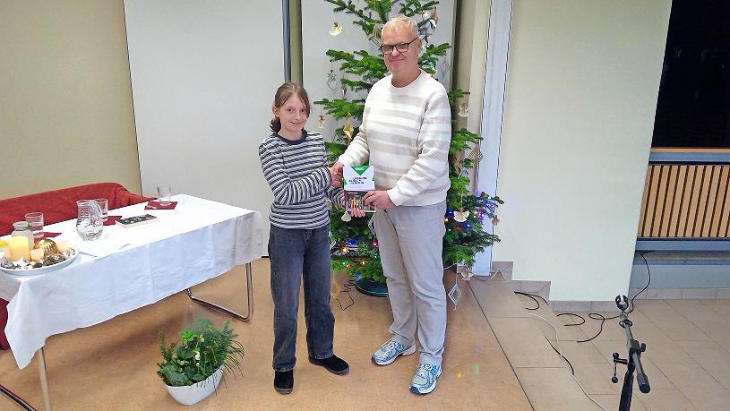 Schulleiter Christian Buchner überreicht der Gewinnerin ihren Preis.