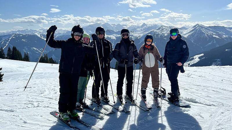 Jugendliche zusammen mit Skicampleiter Julian Hick (rechts) beim Skifahren.