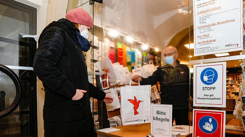 &Uuml;ber ein Abholfenster &uuml;berreicht Thomas Z&ouml;lch-Buba  der Buchhandlung "Collibri" seinen Kunden die B&uuml;cher.