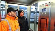 Jürgen Hälter (l.) vom Bahnhofsmanagement Nordfranken und Bürgermeister Mario Schönwald fahren mit dem Aufzug nach unten.