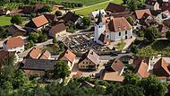 Ausschnitt aus einer Luftaufnahme von Moggast: Der Dorfweiher befindet sich links vor der Friedhofsmauer.Forchheim & Fränkische Schweiz