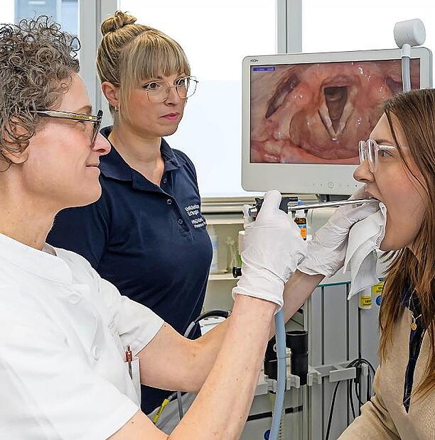 Anne Sch&uuml;tzenberger (l.), Leiterin der Fachabteilung Phoniatrie und P&auml;daudiologie der HNO-Klinik des Uniklinikums Erlangen, untersucht mittels Videostroboskopie die Stimmlippenschwingung einer Patientin.