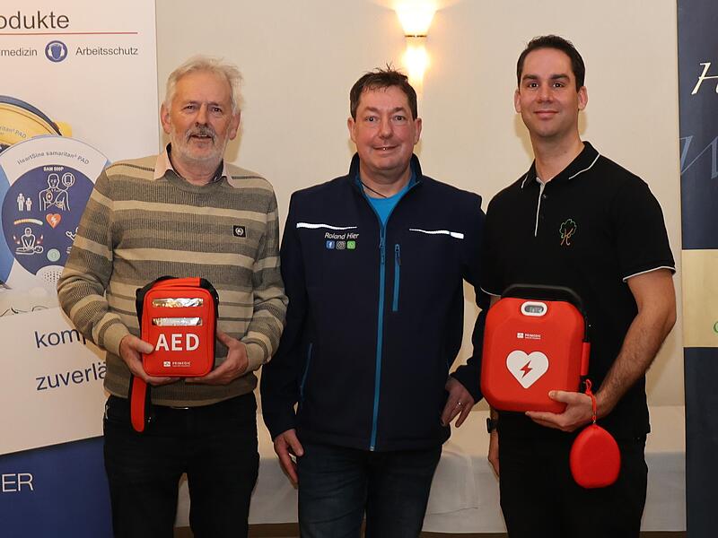 Edwin Schmitt (l.) und Stefan Kammermayer (r.) haben daf&uuml;r gesorgt, dass es in Dormitz zwei weitere Defibrillatoren gibt. Roland Hier vom Rettungsdienst gab die Instruktionen.