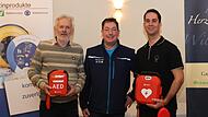 Edwin Schmitt (l.) und Stefan Kammermayer (r.) haben daf&uuml;r gesorgt, dass es in Dormitz zwei weitere Defibrillatoren gibt. Roland Hier vom Rettungsdienst gab die Instruktionen.