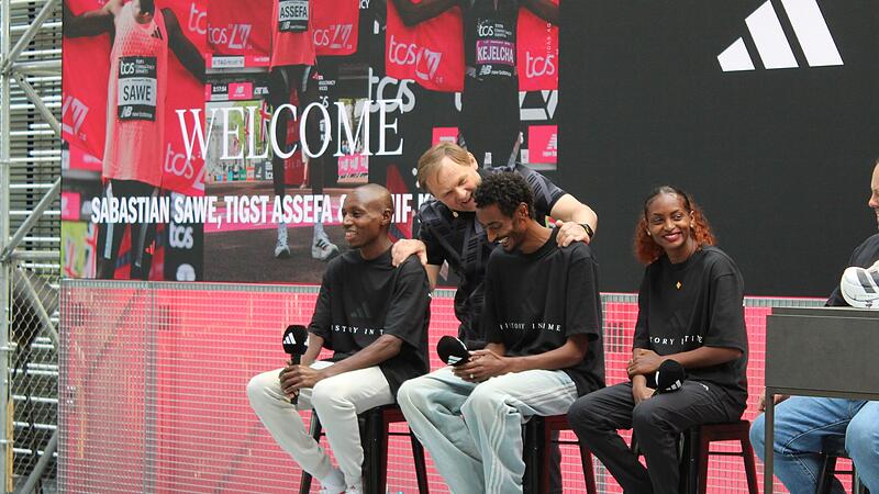 Sabastian Sawe (v.l.), Yomif Kejelcha und Tigist Assefa lassen sich in Herzogenaurach nach ihren Rekorden beim London-Marathon unter anderem von Adidas-CEO Bj&oslash;rn Gulden feiern.