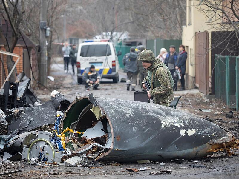 Ein Soldat der ukrainischen Armee inspiziert Fragmente eines abgestürzten Flugzeugs. Es war unklar, wessen Flugzeug abgestürzt ist und wer es zum Absturz gebracht hat. Russische Truppen sollen bis in die Außenbezirke der Hauptstadt vorgedrungen sein. Russland hat am Donnerstag einen umfassenden Angriff auf die Ukraine gestartet und Städte und Stützpunkte mit Luftangriffen oder Granaten beschossen.
