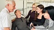 Schulleiter Andreas Schneider hebt gemeinsam mit Hanna, Lisa und Suzanna eine Patientenpuppe aus dem Krankenbett in der Berufsfachschule für Pflege im Klinikum Forchheim-Fränkische Schweiz.Forchheim & Fränkische Schweiz