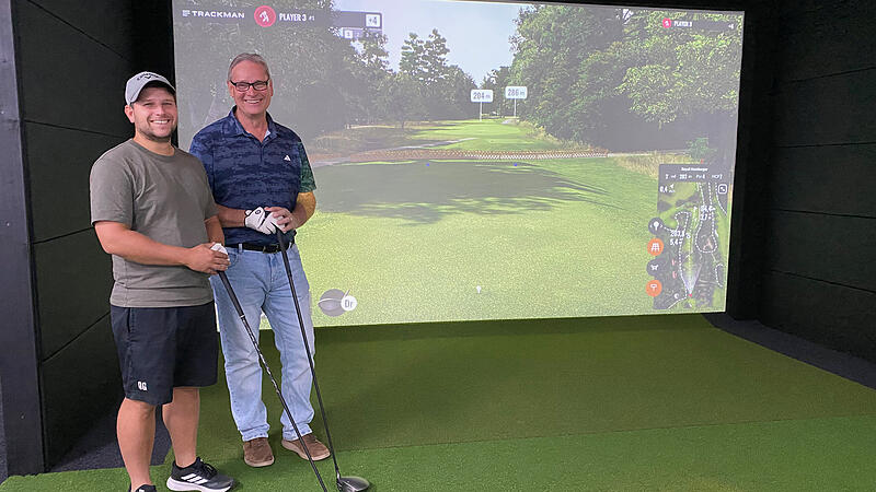 Golf Lounge in EggolsheimForchheim & Fränkische Schweiz Adrian und Stephen Robillard vor der Leinwand des Golfsimulators