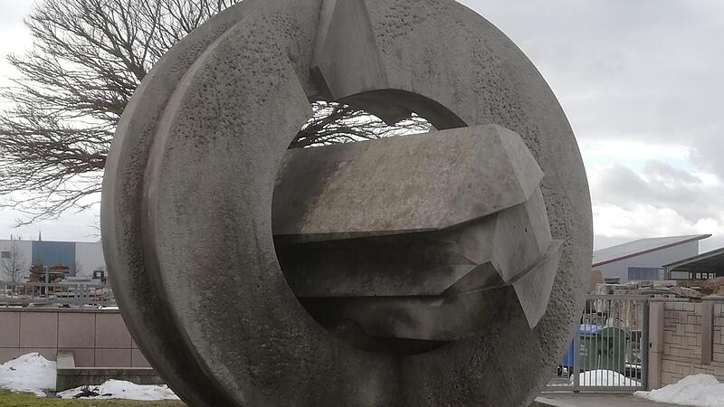 Die Kreisscheibe mit Querriegel steht vor den Natursteinwerk Graser.