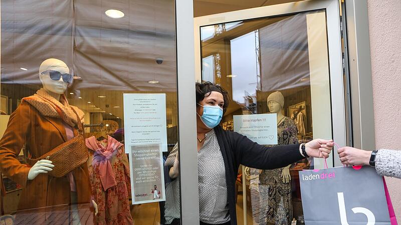 Heike Ammon übergibt eine Überraschungstüte an eine Kundin. Überraschungstüten sind ihr Mittel der Wahl, um die Winterware noch los zu bekommen.Forchheim & Fränkische Schweiz