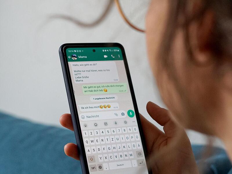 Eine Frau  hat auf ihrem Smartphone  den  Messengerdienst Whatsapp geöffnet.