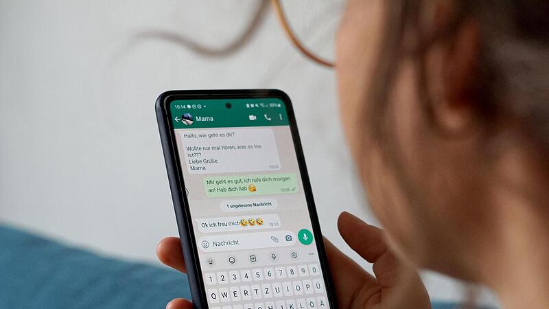 Eine Frau  hat auf ihrem Smartphone  den  Messengerdienst Whatsapp geöffnet.