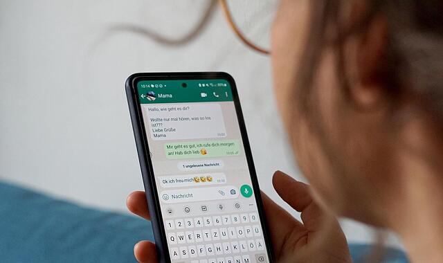 Eine Frau  hat auf ihrem Smartphone  den  Messengerdienst Whatsapp geöffnet.