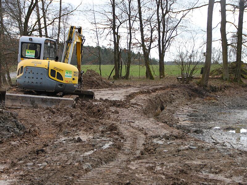 Der Bagger zieht eine Furche, damit dort der Zaun eingebracht werden kann.
