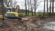Der Bagger zieht eine Furche, damit dort der Zaun eingebracht werden kann.