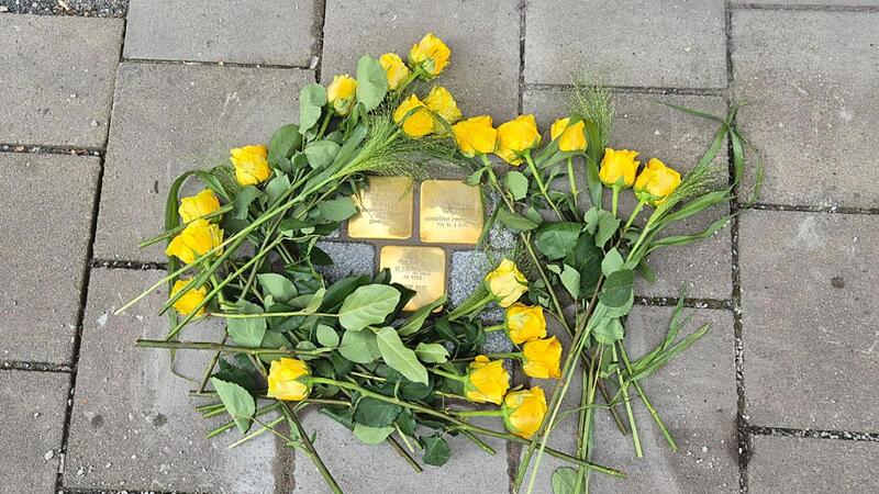 Die Besucher der Gedenkstunde legten an den neuen Stolpersteinen gelbe Rosen nieder, die Lieblingsblumen von Kurt Baum.