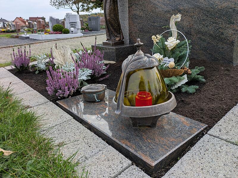 Kerzenlicht, Engel und Blumen sind Zeichen der Verbundenheit am Allerheiligentag.