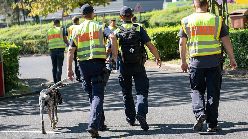 Mit einem Spürhund durchsuchten Polizeibeamte am Samstag das Gebiet am Schulzentrum in Lohr am Main. Tags zuvor war hier ein toter Jugendlicher gefunden worden.