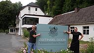 Jens und Melanie Zweck vor ihrem Schild &bdquo;Zeitinsel Doos&ldquo;, dahinter das Hostel.Forchheim & Fr&auml;nkische Schweiz