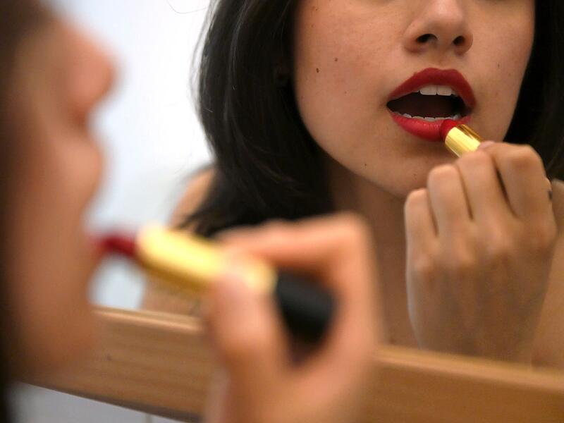 Lippenstift auftragen vor dem Spiegel Lippenstift auftragen vor dem Spiegel