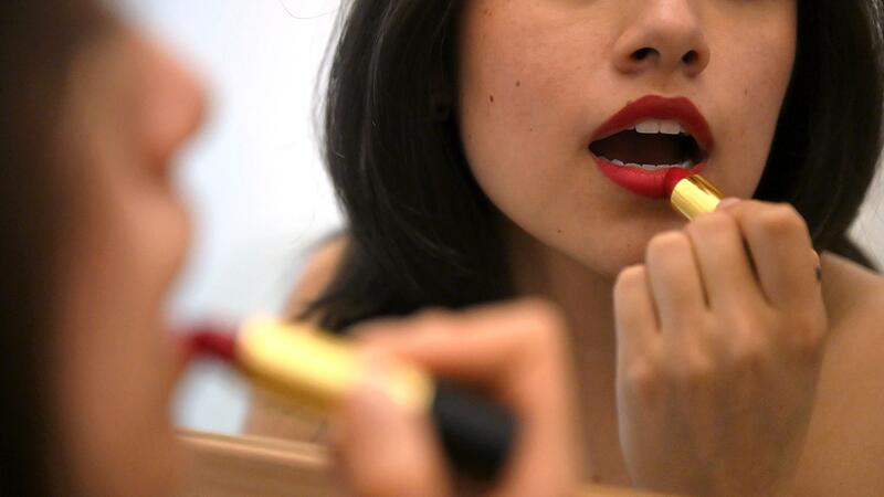 Lippenstift auftragen vor dem Spiegel Lippenstift auftragen vor dem Spiegel