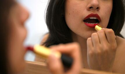 Lippenstift auftragen vor dem Spiegel