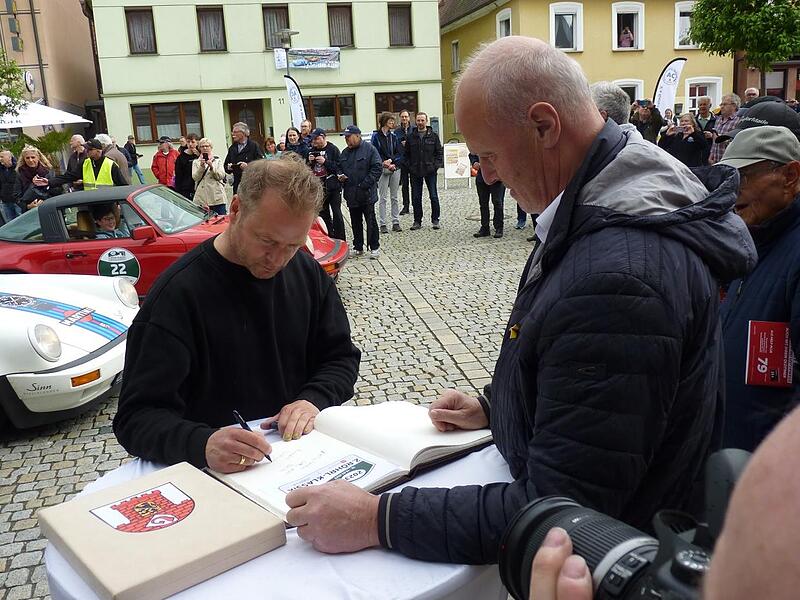 Hinnerk Sch&ouml;nemann tr&auml;gt sich in das Goldene Buch der Stadt ein.