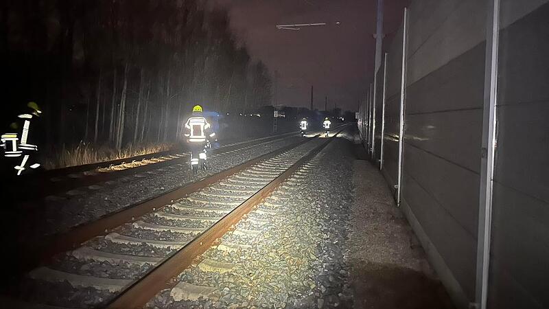 Feuerwehrleute suchen die Gleise bei Baiersdorf ab.