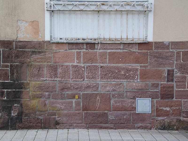 Ehemaliger Eingang, der nach einer Flutkatastrophe und die nachfolgende Anhebung des Gehsteiges zugemauert wurde.Schweizerhaus Café Ehemaliger Eingang, der nach einer Flutkatastrophe und die nachfolgende Anhebung des Gehsteiges zugemauert wurde.