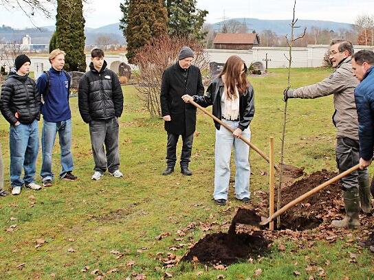 Die Konfirmanden und Kirchenvorst&auml;nde legten unter Anleitung der Angeh&ouml;rigen des Gartenbauvereins Hand an, um die Jungb&auml;ume sachgerecht in die Erde zu bringen