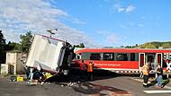 Zug fährt an Bahnübergang gegen Getränkelaster