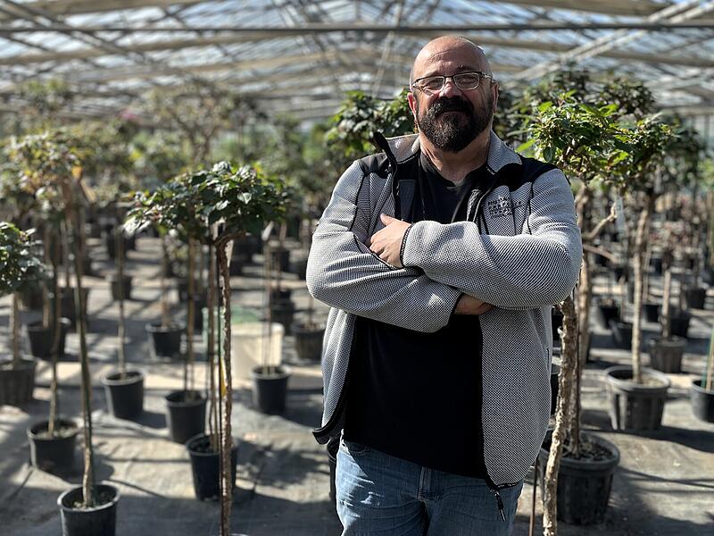 Holger Pfaff, Leiter der Kurg&auml;rtnerei Bad Kissingen, vor hunderten Solit&auml;rb&auml;umen und Stauden, die in einer Gew&auml;chshalle &uuml;berwintert haben.