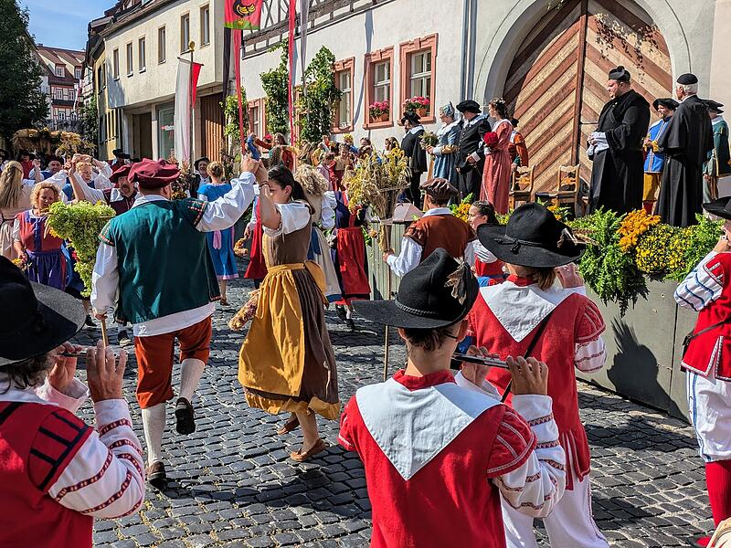 Die B&uuml;rger der Stadt feiern am Festtag Mari&auml; Himmelfahrt 1641 ihr Erntedankfest und tanzen vor dem Haus des Oberb&uuml;rgermeisters.