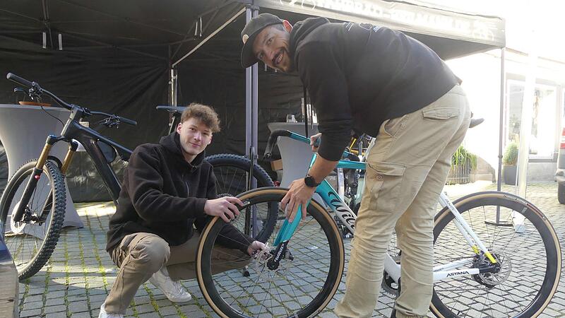 Manuel Heilmann der Firma Fahrrad-Heilmann montiert während der Fahrradmesse in Herzogenaurach mit einem Mitarbeiter ein Fahrrad.