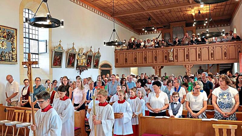 Die Ministranten und Geistliche ziehen in die gut besuchte Pfarrkirche in Schnaid_ein. Mathias Erlwein
