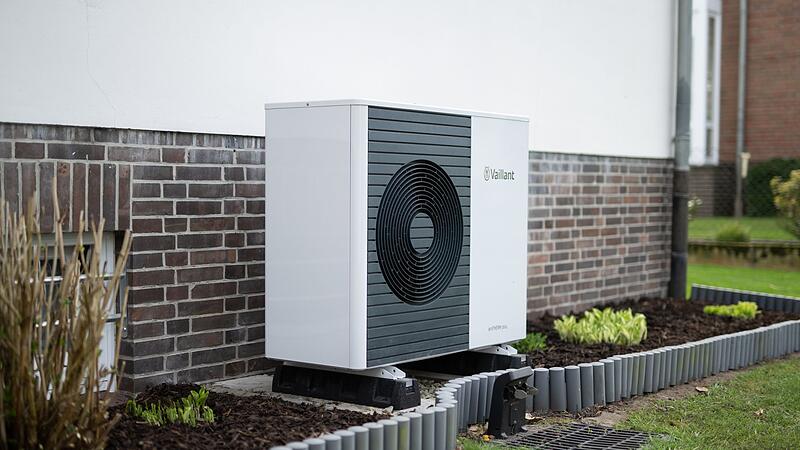 Wärmepumpen-Außengerät vor einem Einfamilienhaus Wärmepumpen-Außengerät vor einem Einfamilienhaus