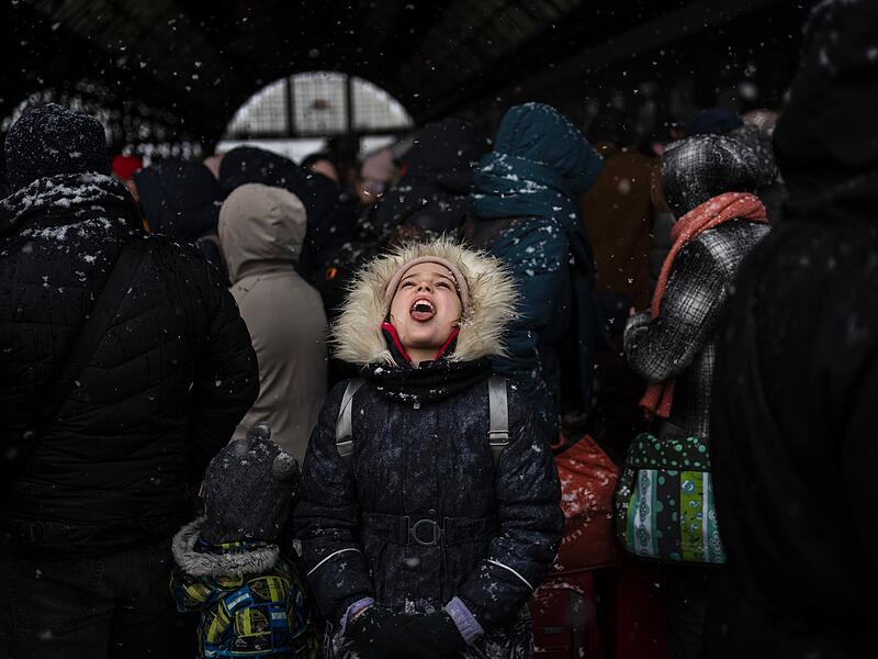 Ein Mädchen fängt Schneeflocken, während es mit anderen darauf wartet, am Bahnhof von Lwiw einen Zug nach Polen zu besteigen. Wegen des russischen Angriffs auf die Ukraine sind nach Angaben des UN-Flüchtlingshilfswerks (UNHCR) etwa 368 000 Menschen auf der Flucht.
