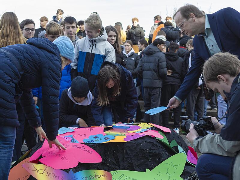 Der „Scherbenfluss-Hoffnungsweg“ verband historische Bildung, Kunst und Musik zu einem nachhaltigen Erlebnis für die Schulgemeinschaft. Am Ende lagen Hunderte bunte Symbole über dem schwarzen Objekt als Zeichen, dass Hoffnung, Menschlichkeit und Z...
