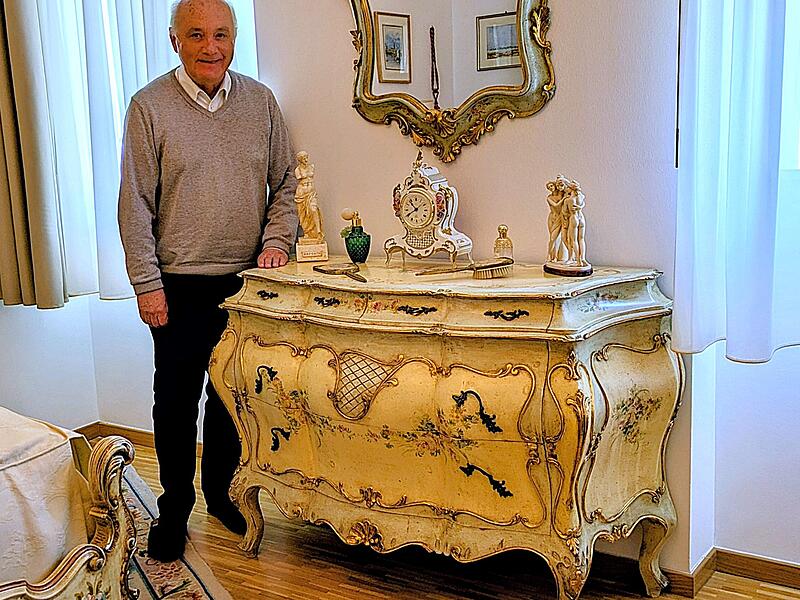 Ortskurator Prof. Reinhard Haus an der restaurierten Schlafzimmer-Kommode im historischen Neurokoko-Stil
