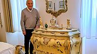 Ortskurator Prof. Reinhard Haus an der restaurierten Schlafzimmer-Kommode im historischen Neurokoko-Stil