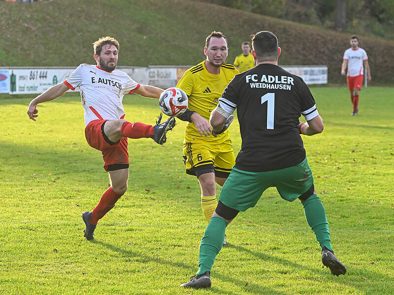 Der Heilgersdorfer Sebastian Steiner streckt sich, kommt aber nicht mehr ganz an den Ball, der sichere Beute für Weidhausens Keeper Lukas Faber ist.