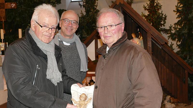 Günter Keppner, Pfarrer Andreas Schlechtweg und Heinz Weidhaus (von links) zeigen das legendäre Christuskind, das ab Heilig Abend wieder in der Krippe liegen wird.