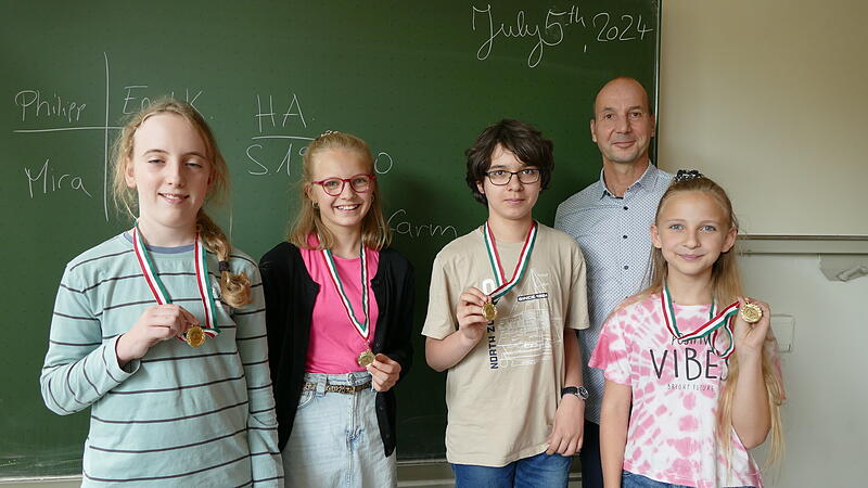 Das erfolgreiche Team des Dientzenhofer-Gymnasiums freut sich mit Lehrer Thomas Platz&ouml;der &uuml;ber die Goldmedaille (von links): Malte, Lina, Milan und Romy.