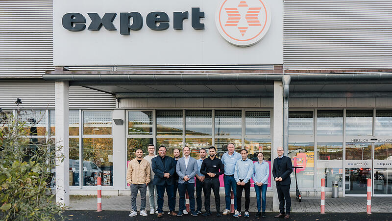 Oberb&uuml;rgermeister Dr. Dirk Vogel (rechts) und Wirtschaftsf&ouml;rderer Sebastian M. B&uuml;nner (Zweiter von links) mit (von links) Volkan Karaslan (Zentraleink&auml;ufer GSM Telekommunikation), Udo Wunder (Projektleiter Zubeh&ouml;r), Christian Weigel (Zentraleink&auml;ufer Kleinger&auml;te), Danny Lanzend&ouml;rfer (Leiter Qualit&auml;tsmanagement), sowie den Expert-Mitarbeitern mit Marktleiter Naweed Mohiuddin (F&uuml;nfter von rechts).
