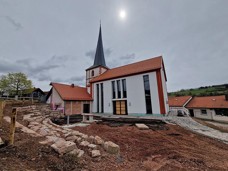 Der historische Kirchturm aus dem 15. Jahrhundert blieb erhalten, der Au&szlig;enbereich rund um den Neubau ist noch Baustelle.