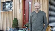 Michael Albert vor einem  holzvertäfelten sogenannten Tiny-Haus. Der Burkardrother Unternehmer möchte Fertighäuser so energieeffizient wie möglich anbieten.