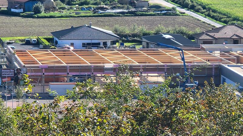 Vom Weg zur Zeiler Gr&uuml;nschnittdeponie aus gesehen, zeigt sich, wie die Dachkonstruktion des neuen Lebensmittelmarktes langsam w&auml;chst.