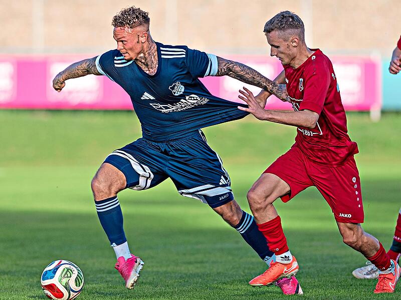 Elias Schmitt (rechts) vom FC Fuchsstadt h&auml;lt den Dampfacher Adrian Hatcher regelwidrig am Trikot fest.Ryan Evans