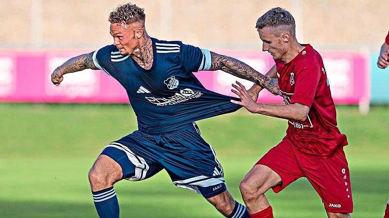 Elias Schmitt (rechts) vom FC Fuchsstadt h&auml;lt den Dampfacher Adrian Hatcher regelwidrig am Trikot fest.Ryan Evans