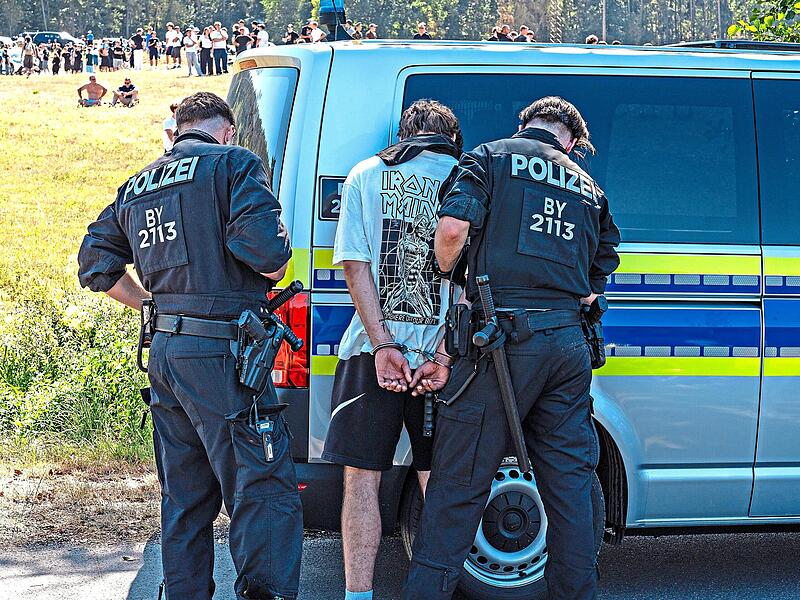 Ein Teilnehmer wird von Polizeibeamten festgenommen.